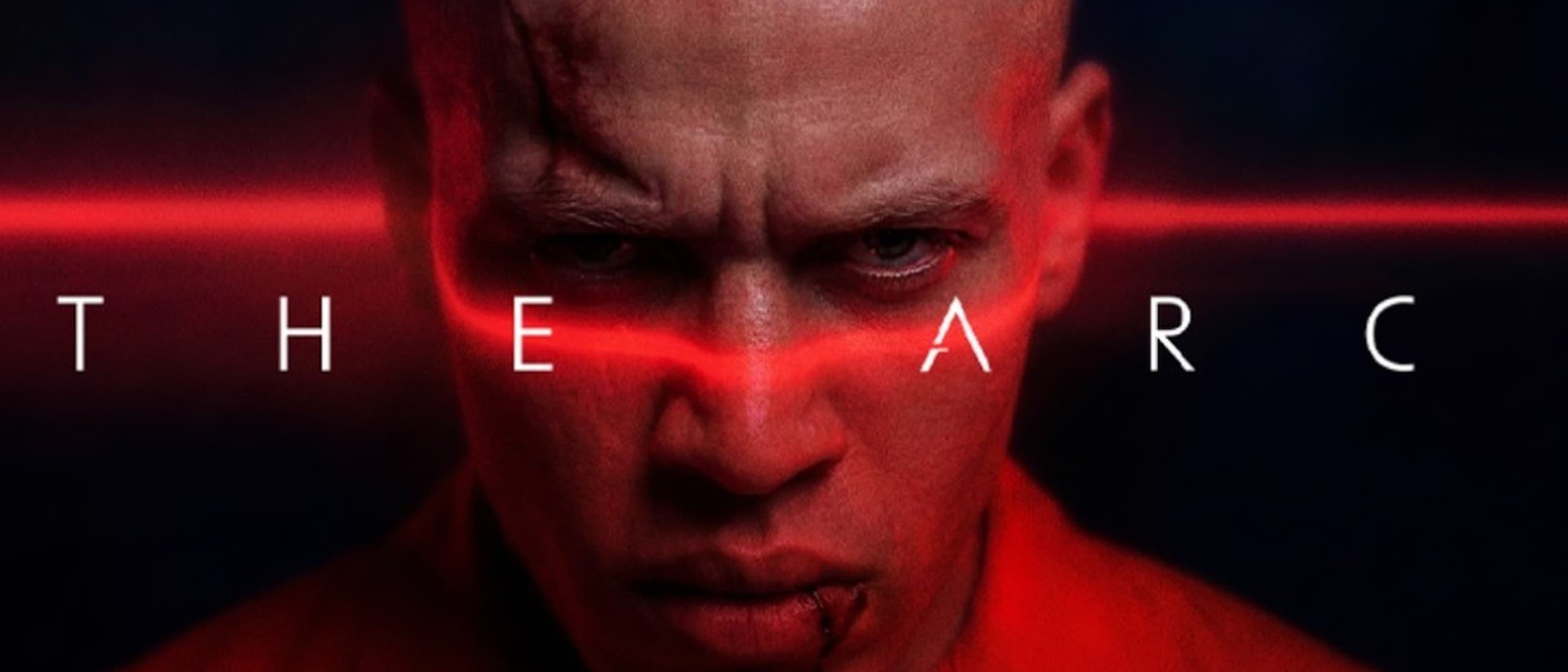 Key art for the AI series The Arc: a scarred, shaven-headed man in an orange prison shirt glares at the camera as a red laser line crosses his eyes behind the spaced-out title