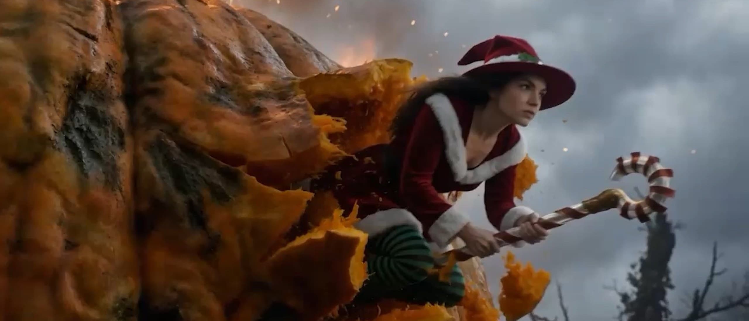 Merry, the film's title witch, in a red Santa-trimmed hat and coat, bursts out of a giant burning pumpkin riding a candy cane under a stormy sky