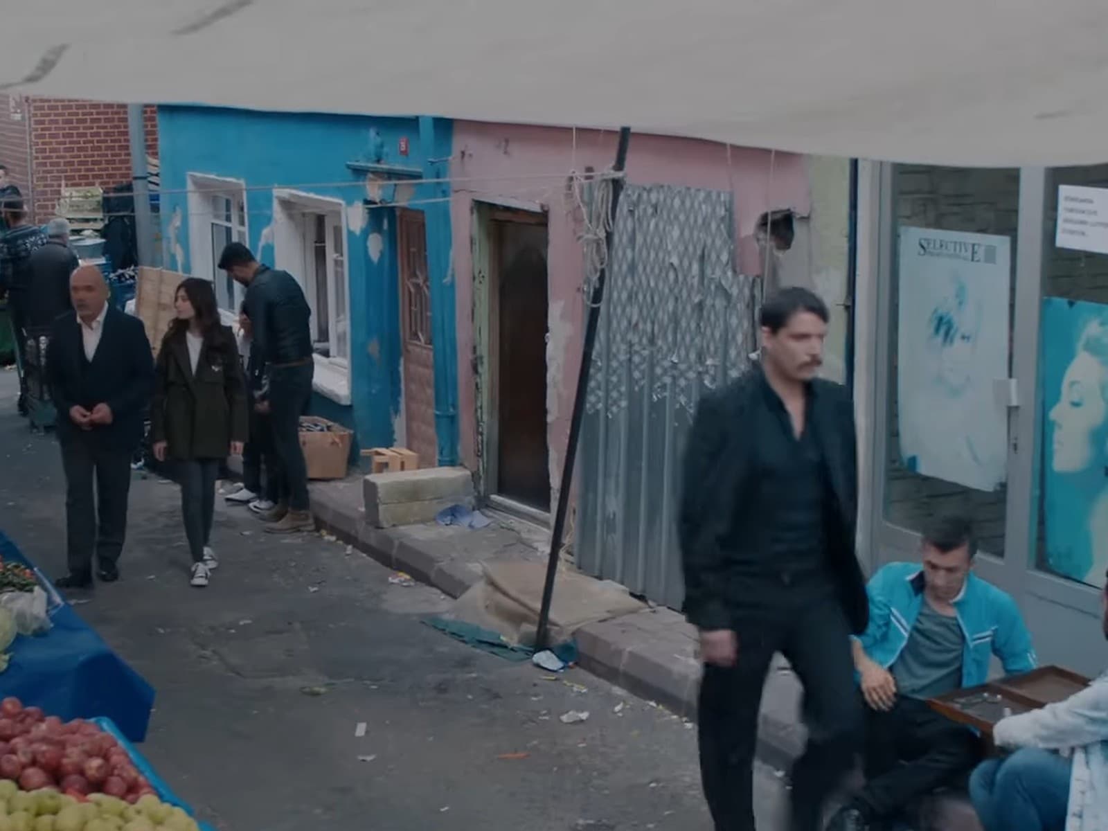 A street market scene from the original Turkish series Çukur (The Pit), with Vartolu walking past stalls